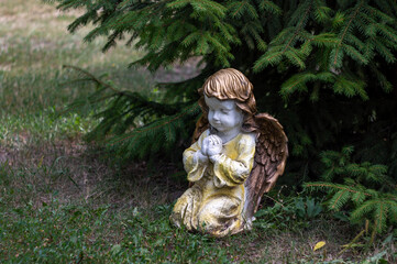 Garden utensils, an angel prays under the tree
