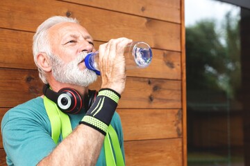 Senior sportsman drinking water during exercise break