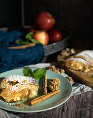 Traditional pieces of apple strudel with cinnamon, grits, powdered sugar and mint.