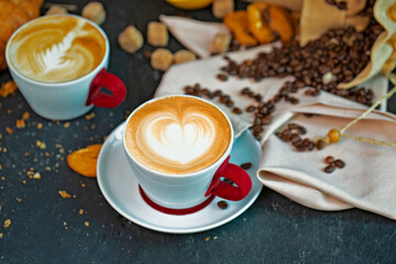 Cappuccino white cup with coffee beans, muffin, croissant, cookies and grapefruit.