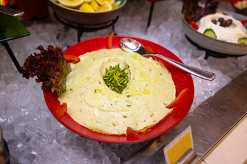 Humus with pistachios in a red plate