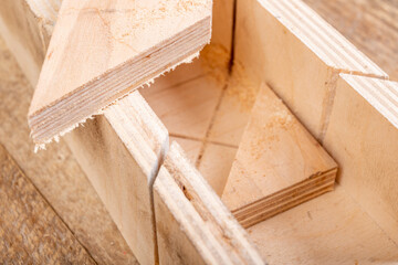 Cutting boards with a handsaw at an angle in the template. Minor carpentry work in the workshop. Light background.