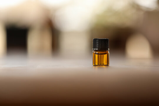 Close Up Macro Image Of 1ml Amber Essential Oil Vial. Health And Wellness Sample With Copy Space.