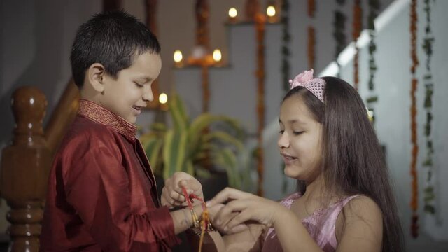  sister tying rakhi, Raksha bandhan to brother's wrist during festival or ceremony - Raksha Bandhan celebrated across India as selfless love or relationship between brother and sister
