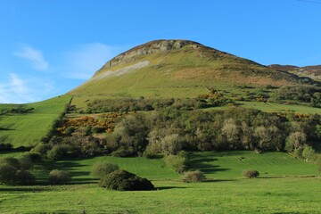 Fototapeta premium Landscape featuring fields of green grass, hills and blue sky at Keelogyboy, County Sligo, Ireland during springtime