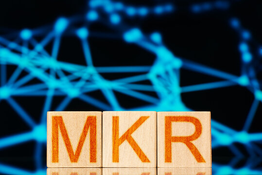 maker. wooden blocks with the inscription mkr on a polygonal background. defi concept