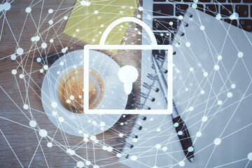 Double exposure of lock hologram drawing over study table background with computer. Concept of data security. Top view.