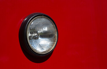 Round headlight of old red tram closeup