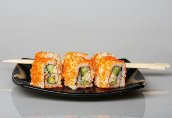 japanese rolls on black plate.