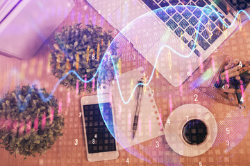 Multi exposure of financial chart hologram over desktop with phone. Top view. Mobile trade platform concept.