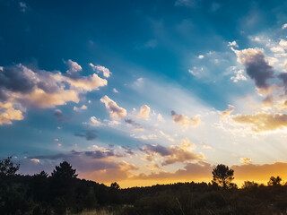 Fototapeta premium Beautiful sunlight through the clouds on a summer sunset