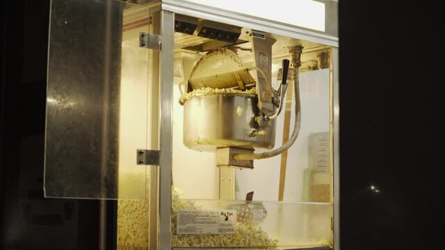 popcorn machine is actively working producing popcorn. Bright car on a dark background. 4K