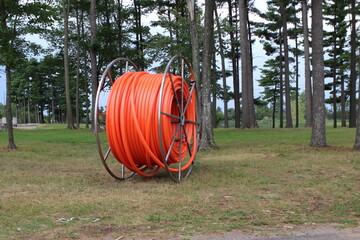 large roll of orange cable in a park