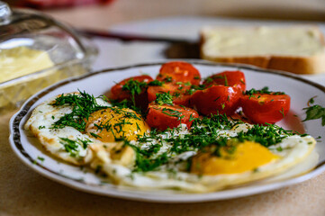 Scrambled eggs with tomatoes and dill, buttered toast for breakfast. Healthy food.