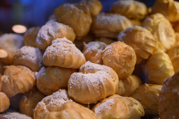 Freshly baked cream puff, pastry with custard. Cakes on the counter in a cafe.