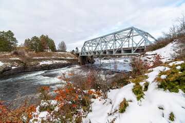 Fototapeta na wymiar The Blue Bridge over the Spokane River at Riverfront Park in downtown Spokane, Washington, covered in snow during winter.