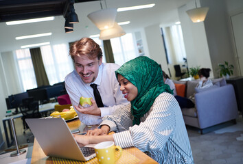 international multicultural business team working together on laptop