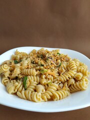 
pasta with vegetables on a plate with a brown background
