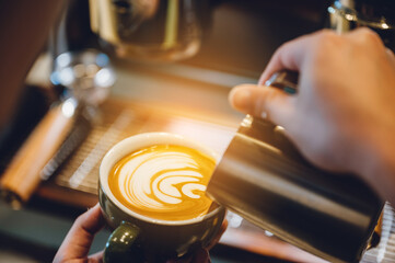 barista making latte art, shot focus in cup of milk and coffee, vintage filter image