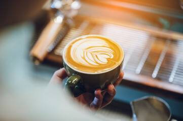 barista making latte art, shot focus in cup of milk and coffee, vintage filter image