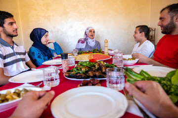 Happy arabic muslim family eating together in a family meeting