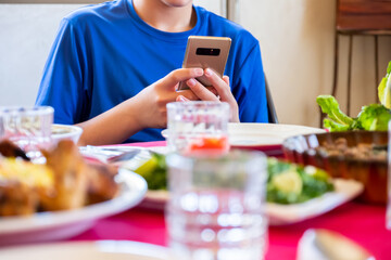 Obraz na płótnie Canvas Arabic Muslim boys using their smartphones while eating 