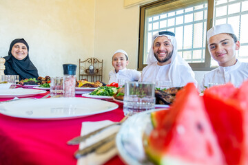 Happy Arabic Muslim family eating together in a family meeting 