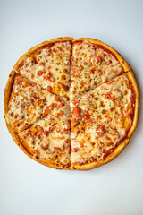 Tasty margarita pizza on baking paper on light table top view vertical