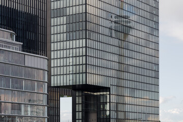 Fototapeta na wymiar Outdoor scenery, exterior glass modern facade of Hyatt Regency Düsseldorf hotel with reflection of Rhine Tower at Medienhafen.