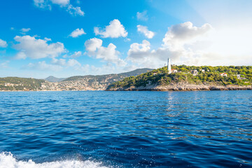 Fototapeta na wymiar View from the Mediterranean Sea of the Saint Jean Cap Ferrat lighthouse as the sun begins to set on the French Riviera in the South of France.