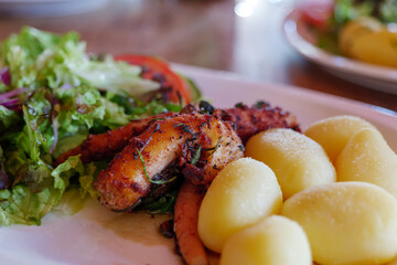 Close up and selected focus view at Portuguese style, Grill Octopus with Boiled Potatoes and Salad.