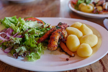 Close up and selected focus view at Portuguese style, Grill Octopus with Boiled Potatoes and Salad.
