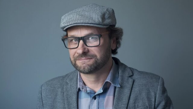 portrait of a handsome Cheerful joyful young man y  in cap smiling and winking provocative to the camera