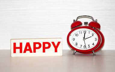 Happy Hours is written by cubes with letters with a black and white classic alarm clock on white background