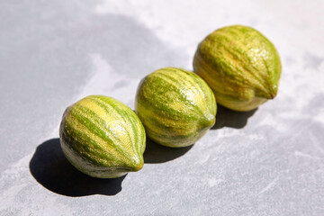 Variegated pink lemons or pink-fleshed Eureka lemons on gray concrete table. Whole citrus fruits with striped rind