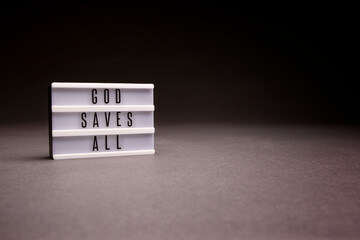 God Saves All message board shot in studio with dramatic lighting and copy space.