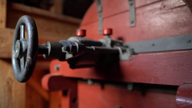 Panning view of large steel valve in an old watermill.