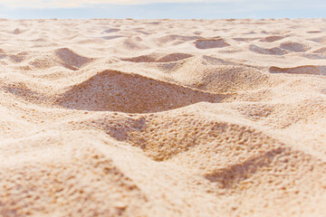 Close up empty sandy beach with blue sky.