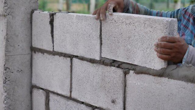 Worker use cement block in the building construction or plaster house construction