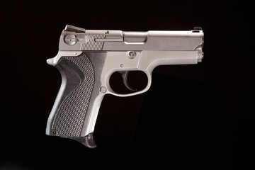Silver pistol on black background, shot in studio.