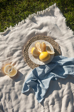 Yellow australian grayfruit cut into pieces in white porcelain vintage plate. The plate staying on the wooden stand. Outdoor.