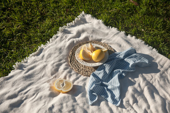 Yellow australian grayfruit cut into pieces in white porcelain vintage plate. The plate staying on the wooden stand. Outdoor.