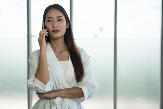 Young Asian Woman Talking On Mobile Phone With Seriously.