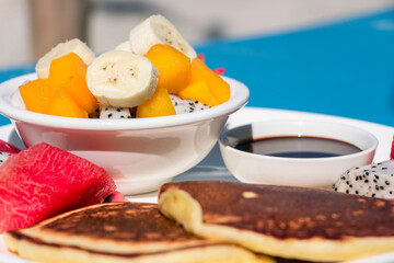 A fruit salad with panckes and chocolate sauce breakfast