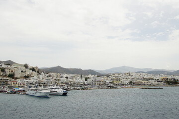 Fototapeta na wymiar the ferry arriving at white buildings island, Greece, Europe