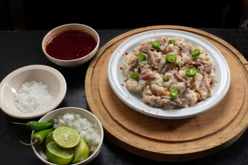 Pozole seco, typical food from colima Mexico accompanied by lemon, onion, sauce, salt on a circular plate