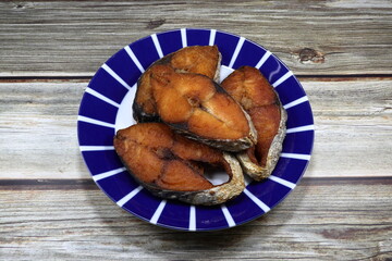 Deep fried Spanish mackerel fish fillet on the plate. Famous crispy fish in Asia restaurant. 