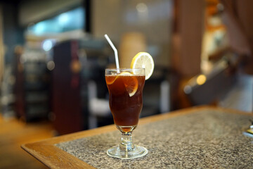 A glass of Iced lemon tea on table and blurred background, Summer Cocktail or Tropical Mocktail, Healthy drink concept.