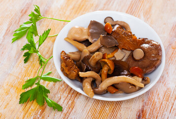 Assorted pickled mushrooms with onions and parsley closeup