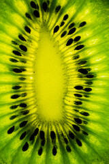 close up of kiwi fruit.  cutaway closeup of a kiwi pith. bright green heart of kiwi. kiwi seeds. fruit texture. fruit slices. half kiwi. closeup of the heart of a green juicy ripe fruit